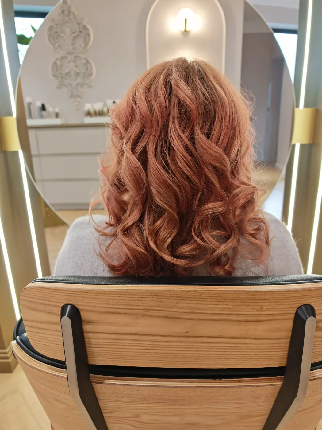 Păr arămiu cu onduleuri definite, colorat și coafat în salon