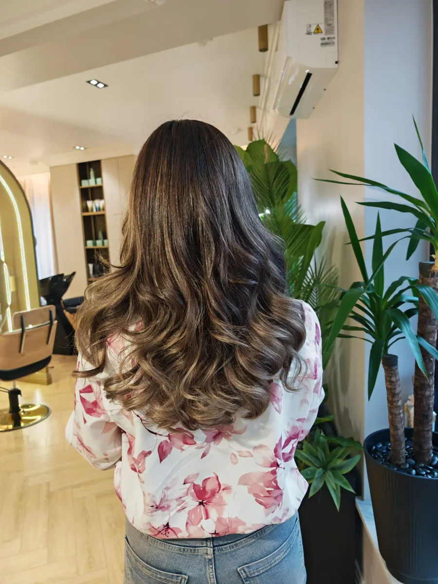 Balayage pe păr brunet lung, cu bucle ample și reflexii aurii