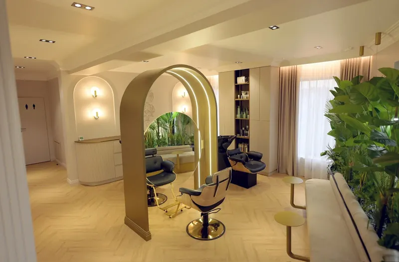 Zona de hair: arcada aurie cu oglinda rotundă, scaunele și spălătorul