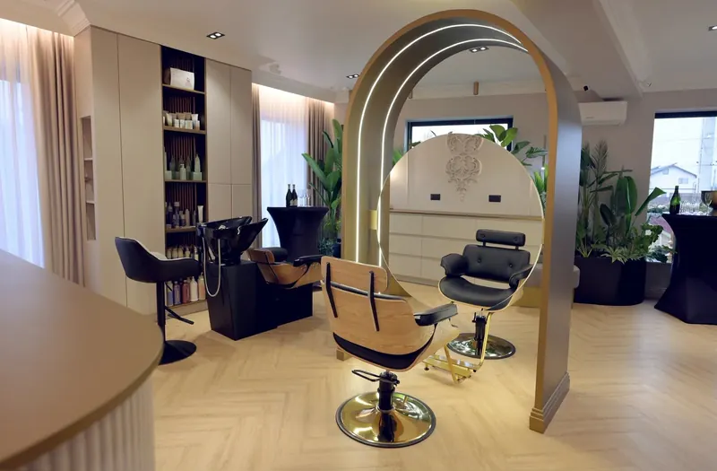Zona de hair cu spălător, scaune de coafor și raftul cu produse
