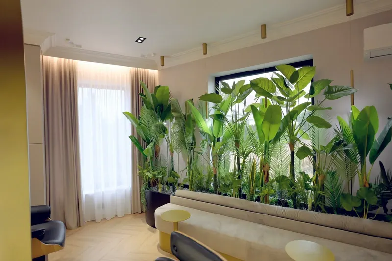 Lounge-ul cu canapea și peretele de plante, lângă fereastră